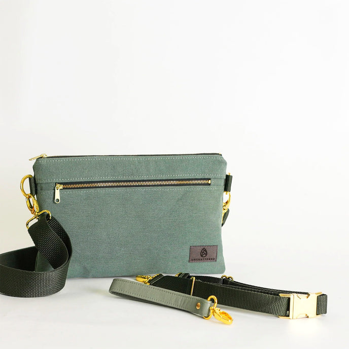 Green 3-in-1 bag with gold zipper and matching strap on a white background