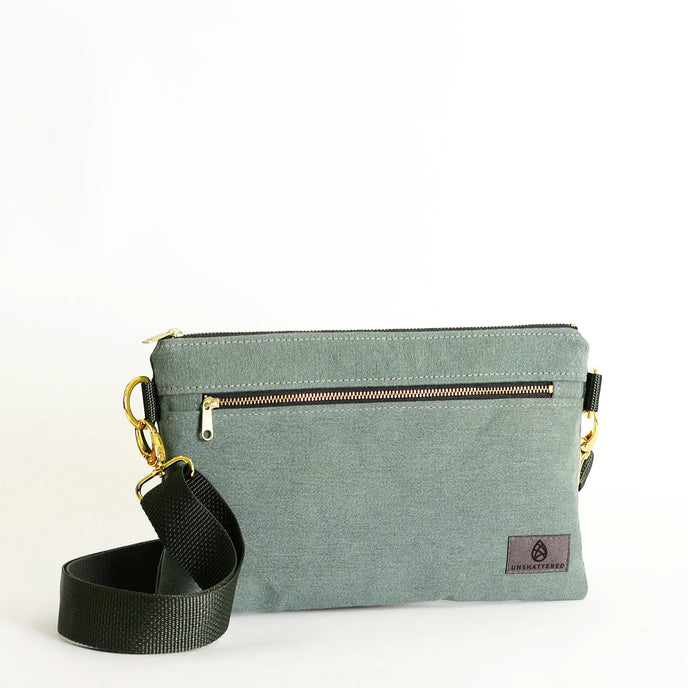 Green crossbody bag with a strap on a white background