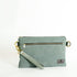 Green wristlet bag with a strap on a white background