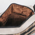 Close-up of a bag with brown interior lining on a white background