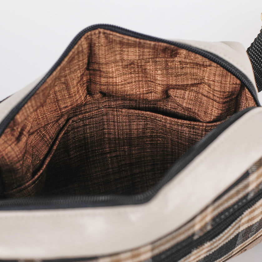 Close-up of a bag with brown interior lining on a white background