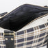 Plaid bag with open zipper showing black interior