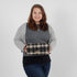 Woman holding a plaid bag against a plain background