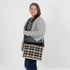Woman holding a plaid bag against a white background