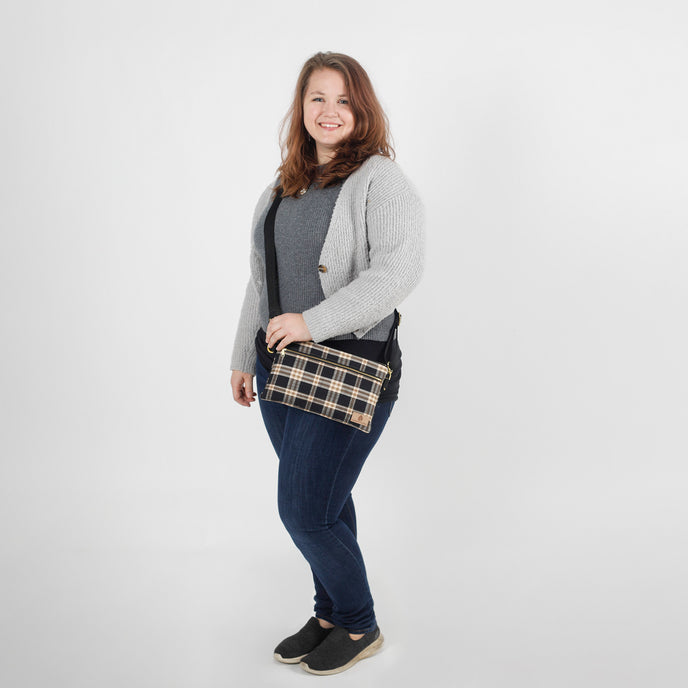 Woman holding a  plaid clutch against a white background