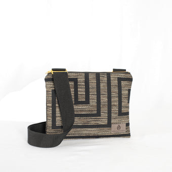 Crossbody pouch with geometric pattern and black strap on a white background
