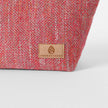 Pink  textured fabric with a tan label on a white background