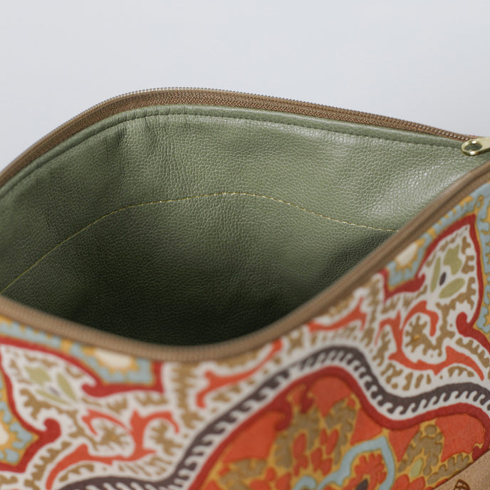 Close-up of a patterned pouch with a green interior on a white background