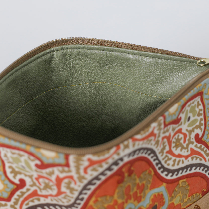 Close-up of a patterned pouch with a green interior on a white background