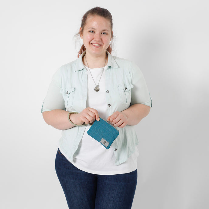 Person holding a blue clip pouch against a white background