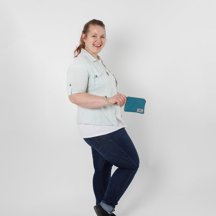 Person holding a blue clip pouch against a white background