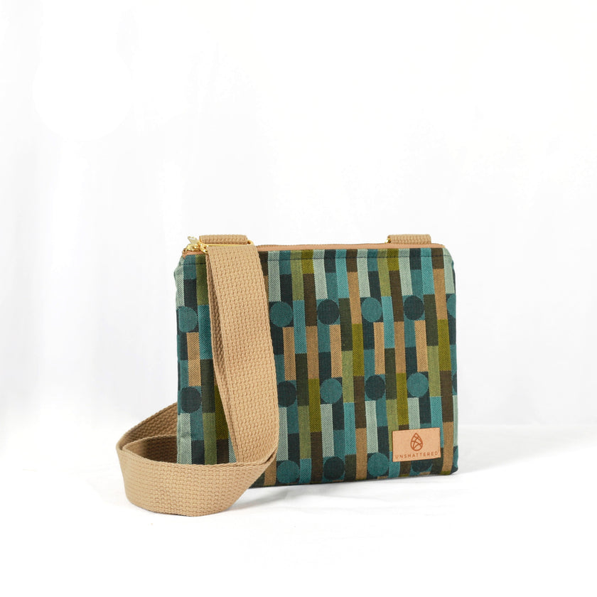 Crossbody bag with geometric pattern and beige strap on a white background