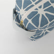 Blue and white patterned pouch with a gold zipper on a white background
