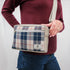 A woman wearing a blue Mercedes plaid errand bag with gray luxury leather alternative accent with silver tone hardware 