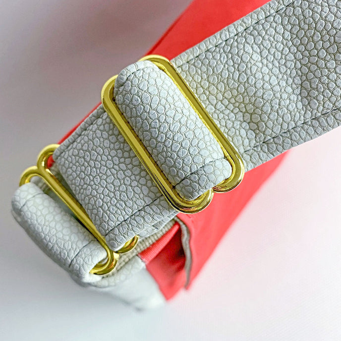 A gold toned hardware on a formula e racing large messenger with cream pebbles fabric as accents