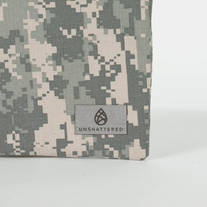 A gray Unshattered label on an upcycled army camo material 