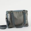 A charcoal  and blue convertible handbag with gold-tone hardware, an adjustable crossbody strap, and a floral patterned interior.