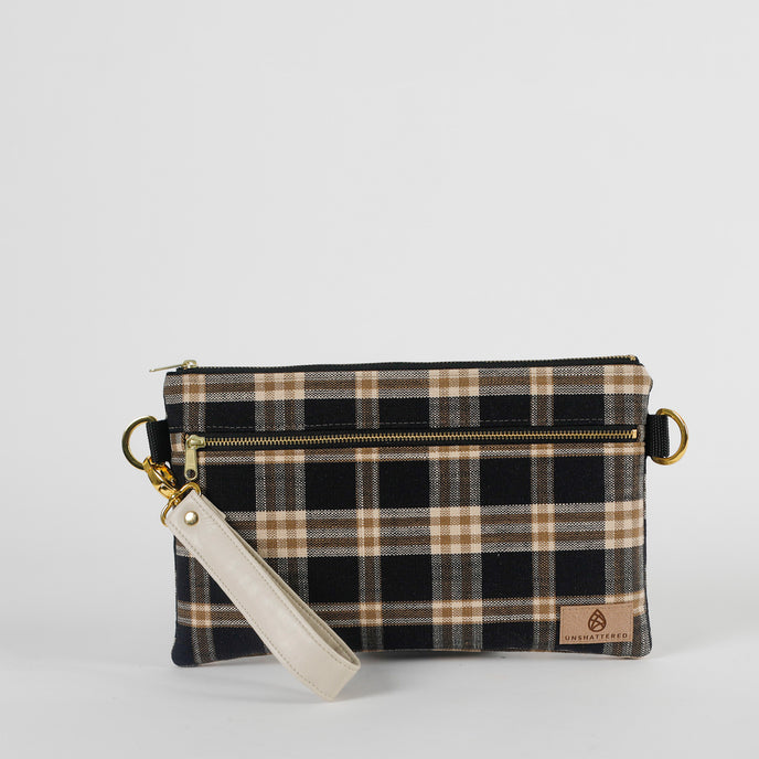 Plaid patterned pouch with a strap on a white background
