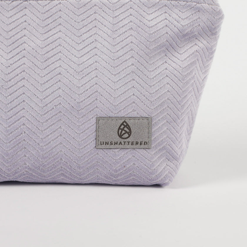 Light Purple fabric makeup kit with 'Unshattered' logo on a white background