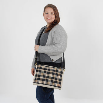 Woman holding a plaid bag against a white background