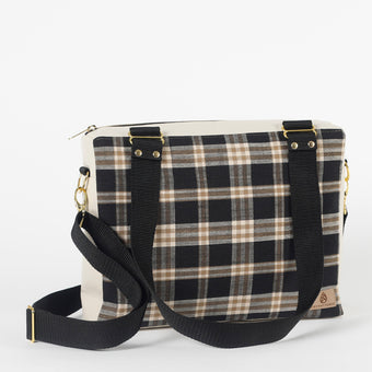 Plaid patterned bag with a black strap on a white background
