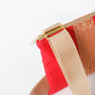 Red pouch with gold strap and zipper on a white background named after Honey 