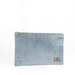 A blue velvet large zip pouch named after Laura with gold-tone hardware, featuring a suede Unshattered label.