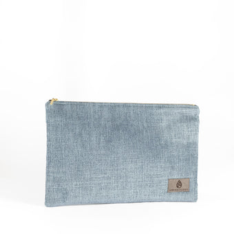 A blue velvet large zip pouch named after Laura with gold-tone hardware, featuring a suede Unshattered label.