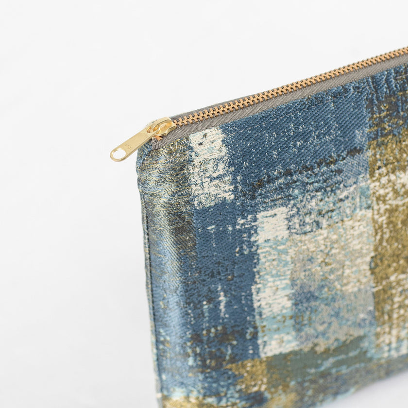 A gold tone zipper on a blue and green splash fabric large zip pouch 
