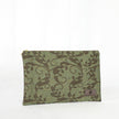 A green floral zip pouch with gold-tone hardware, closed and laid flat on a surface.