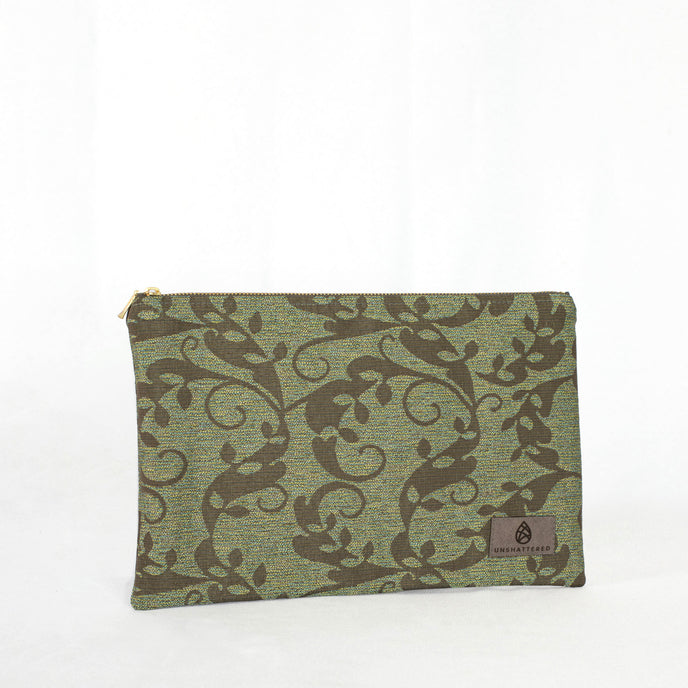 A green floral zip pouch with gold-tone hardware, closed and laid flat on a surface.