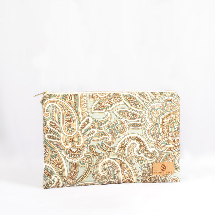 A large zip pouch with a paisley pattern in shades of teal, white, and brown, featuring a neutral fabric liner and gold-tone hardware named after Ariana.