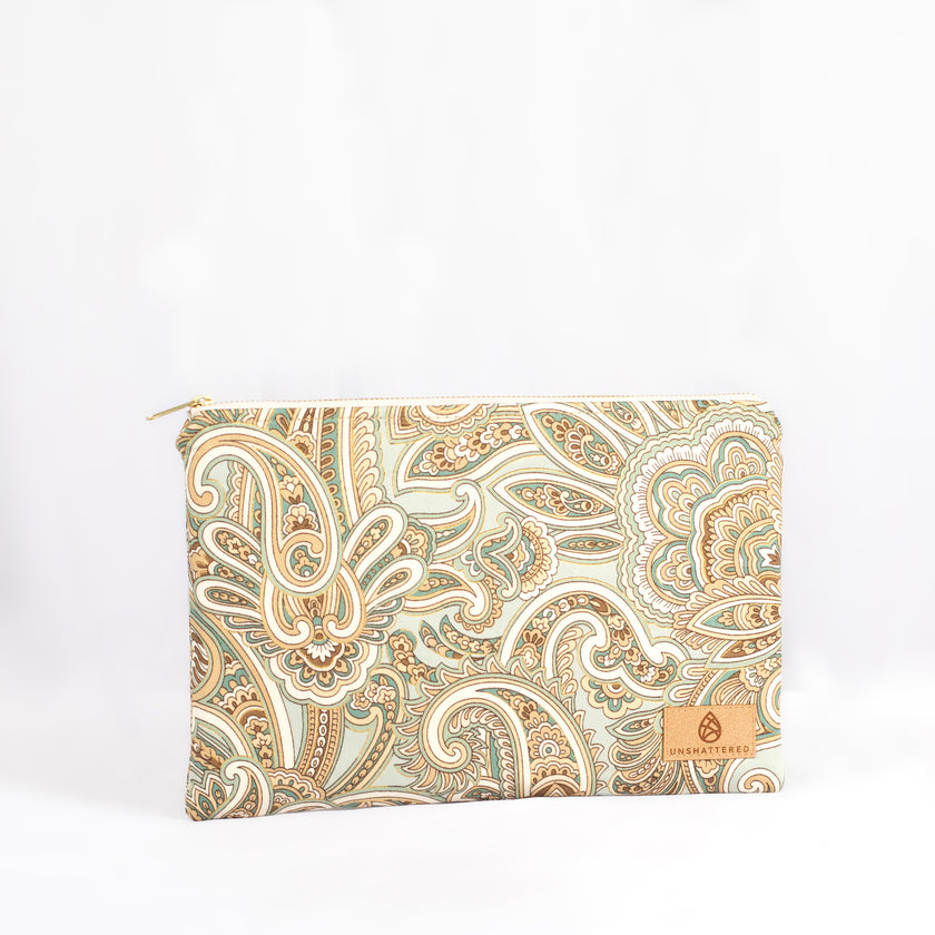 A large zip pouch with a paisley pattern in shades of teal, white, and brown, featuring a neutral fabric liner and gold-tone hardware named after Ariana.