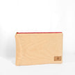 A large zip pouch made with soft, neutral upcycled fabric, featuring a red zipper and a brand tag displaying Unshattered