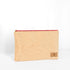 A large zip pouch made with soft, neutral upcycled fabric, featuring a red zipper and a brand tag displaying Unshattered