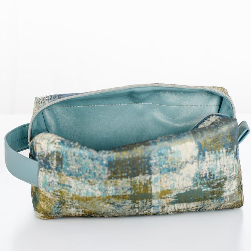 A light blue luxury leather alternative interior on a blue and green toiletry bag