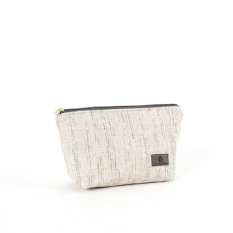 A small zip closure makeup bag made of white tweed fabric with blue and gray stripes, featuring gold-tone hardware.
