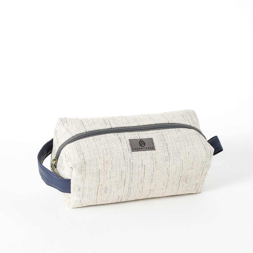 A white two toned twill weave toiletry kit with a zipper closure and a label on the front.