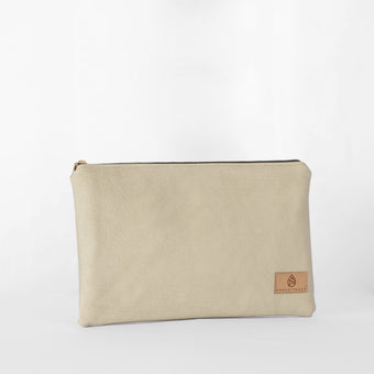 A cream-taupe colored large zip pouch made from luxury leather alternative material, with a starburst printed interior fabric, gold-tone hardware, and a visible brand tag named after Alecia 