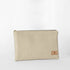 A cream-taupe colored large zip pouch made from luxury leather alternative material, with a starburst printed interior fabric, gold-tone hardware, and a visible brand tag named after Alecia 