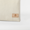 A tan label on a creamy taupe large zip pouch named after Alecia 