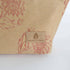 Beige fabric with red floral patterns and 'Unshattered' brand logo on a white background