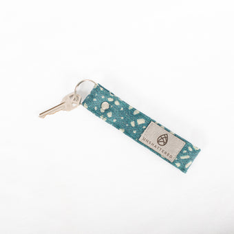 A keychain loop with a silver-tone keyring, featuring a blue and gray dotted pattern on the fabric named after Allison.
