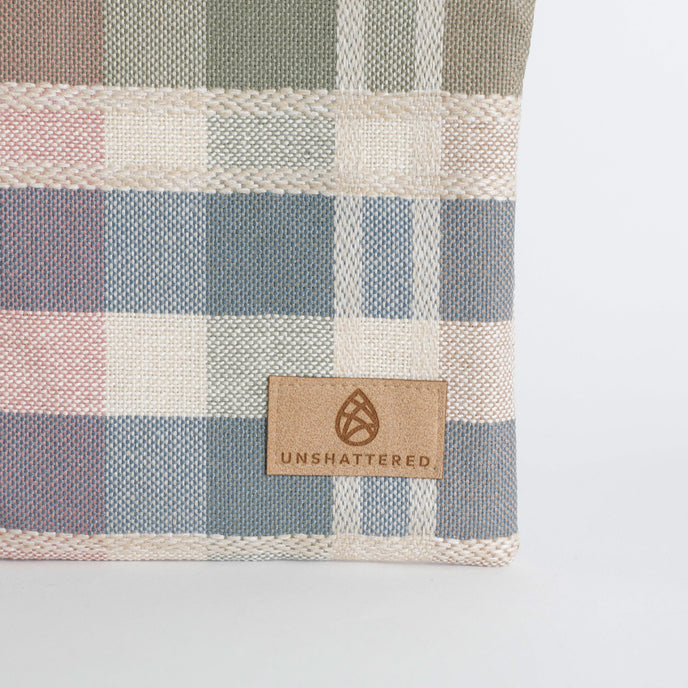 Checkered fabric with a 'Unshattered' logo tag on a white background named after Alyzaah 