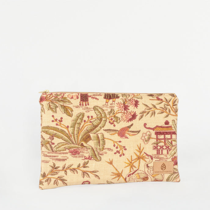 A large zip pouch with an Asian print design, featuring gold-tone hardware and a burgundy fabric interior lining named after Angie 