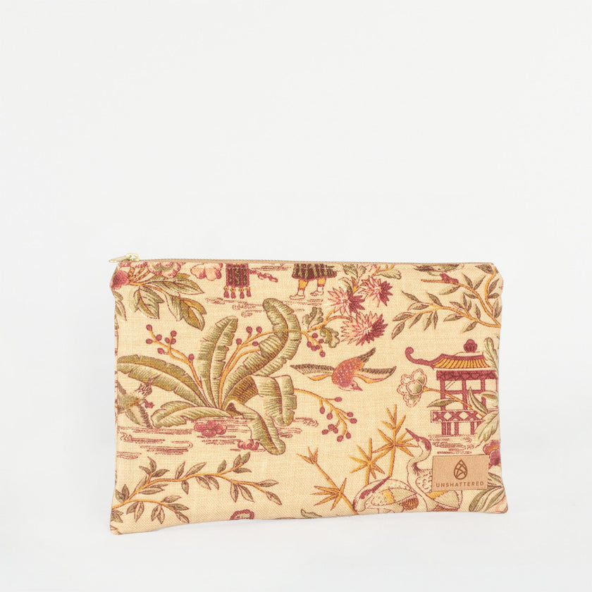 A large zip pouch with an Asian print design, featuring gold-tone hardware and a burgundy fabric interior lining named after Angie 