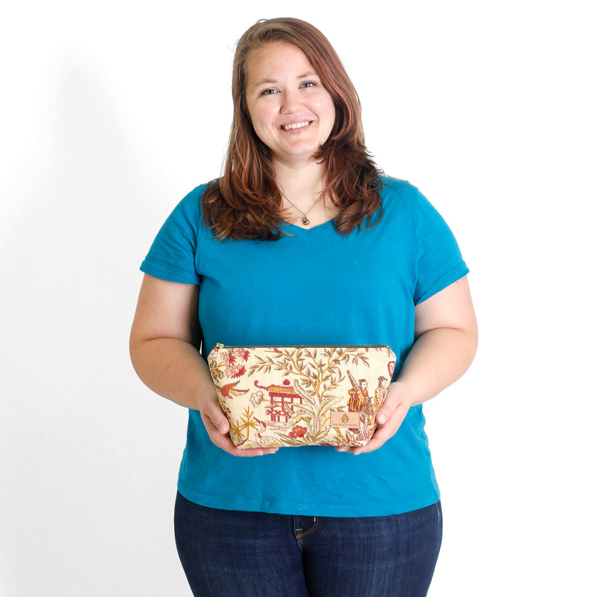 Woman holding a fabric print makeup bag  against a white background named after Anitha 