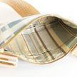Close-up of a striped fabric inside a bag with a gold zipper.