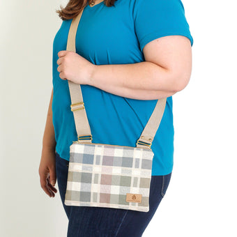 A woman carrying a pastel checkered crossbody bag named after Armani 