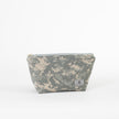 A stylish makeup kit crafted from upcycled army green fabric, featuring a durable gray zipper and a label.